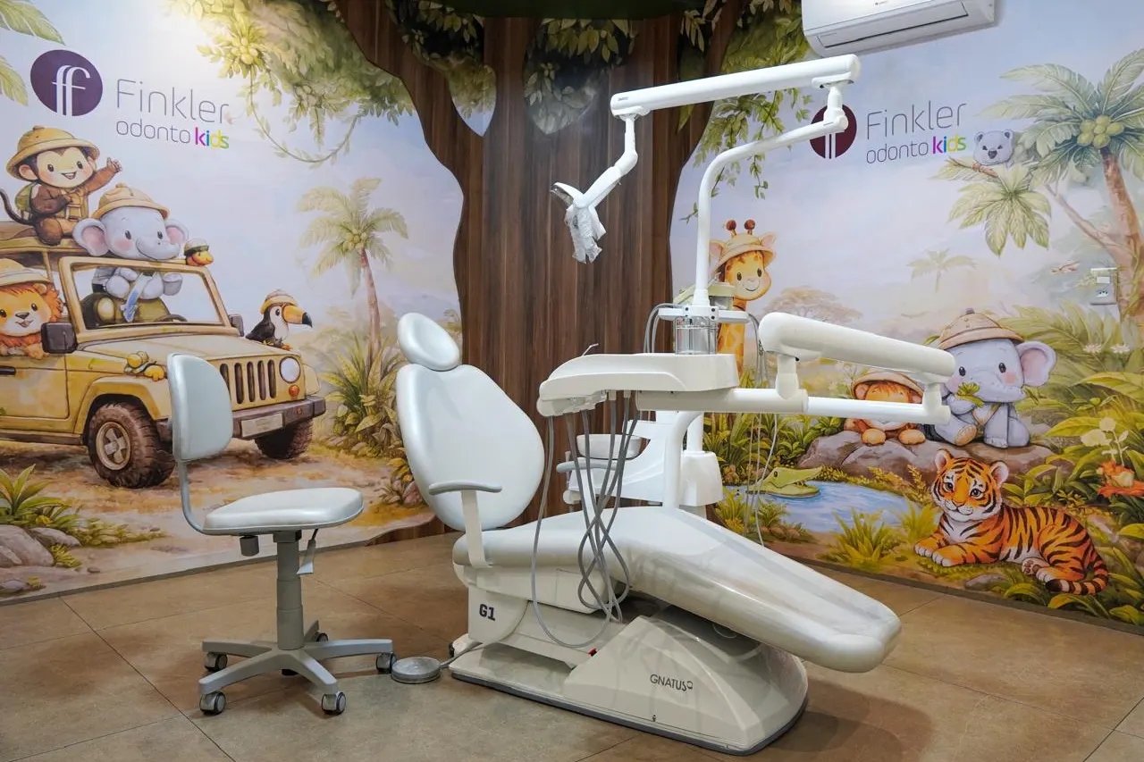 Consultório infantil da Finkler Odontologia, com mural de safári e cadeira odontológica