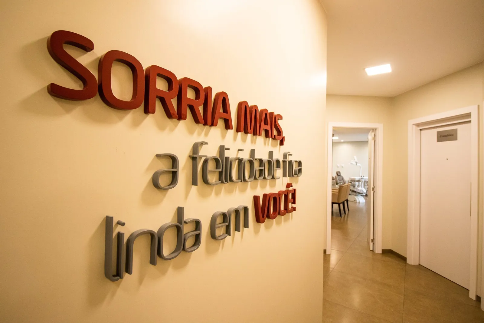 Parede com a frase Sorria mais, a felicidade fica linda em você